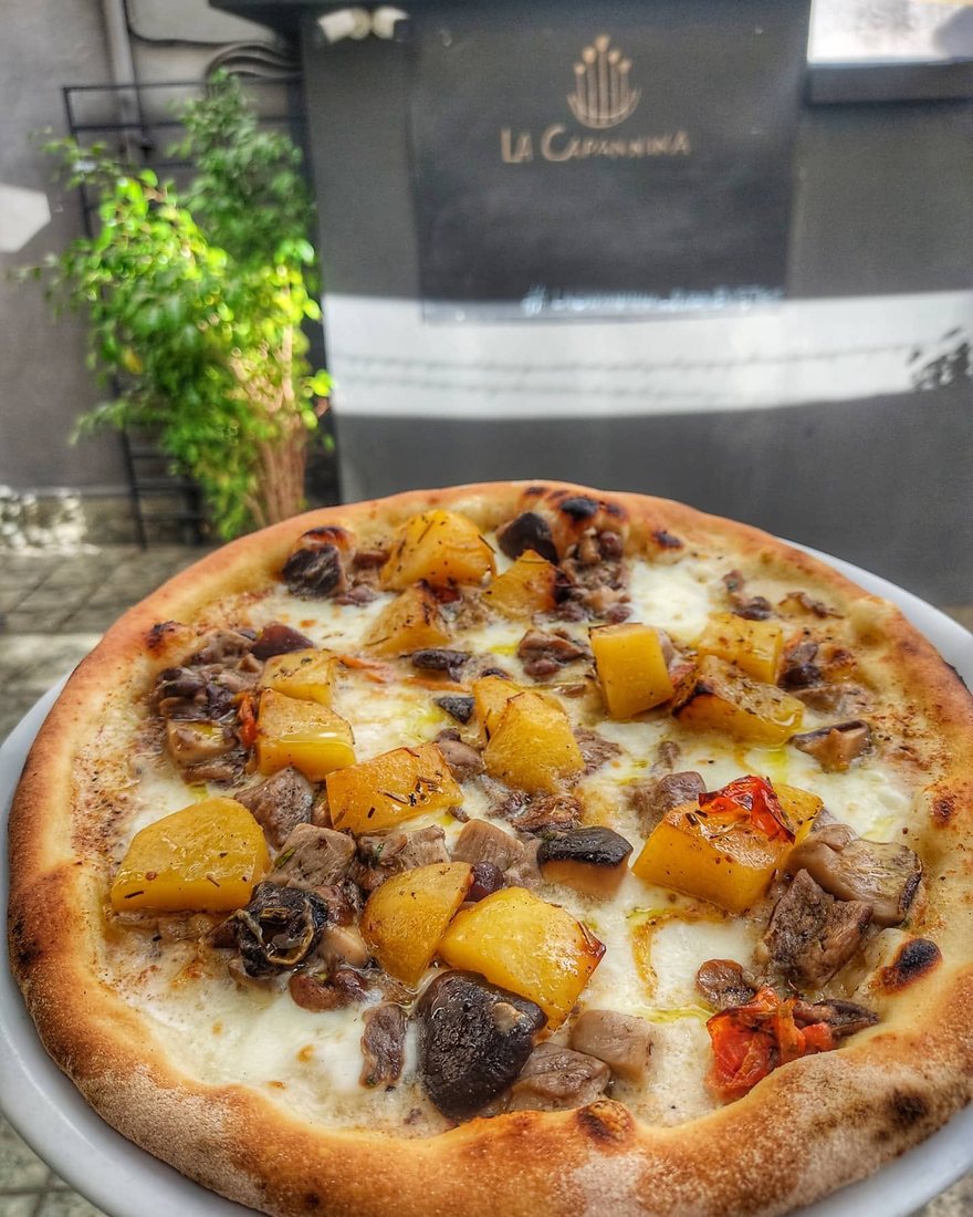 Una pizza servita al tavolo