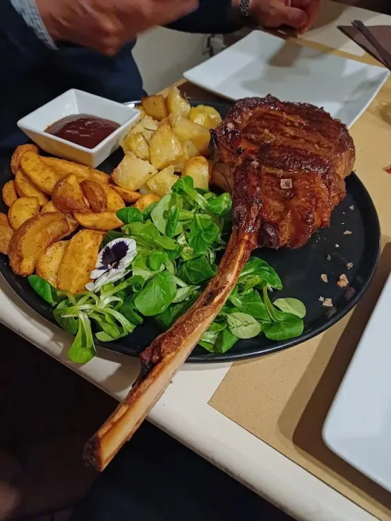 Bistecca tomahawk servita con patate e insalatina